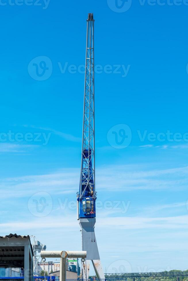 Towering crane amidst a clear blue sky at a busy construction site enhancing city infrastructure and progress photo