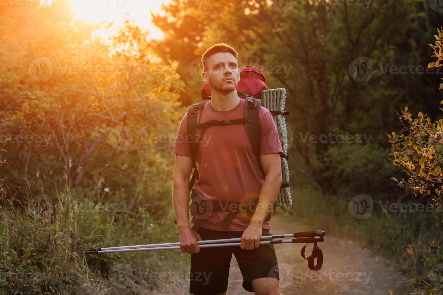 Man hiking with a backpack at sunset photo