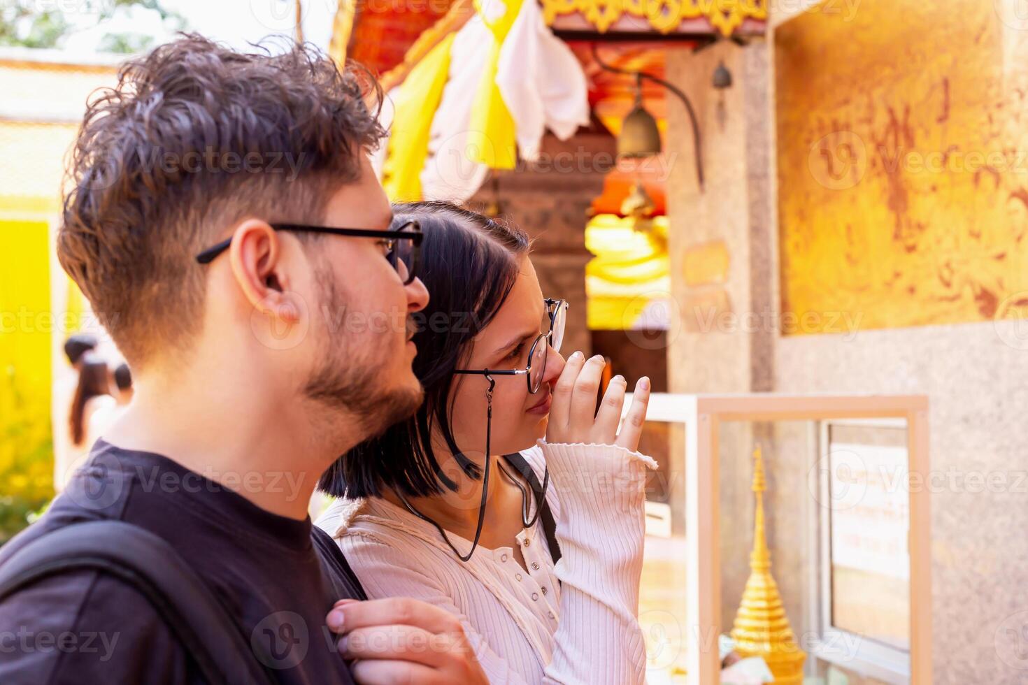 Young couple, engaged in conversation, exploring cultural heritage site with intricate designs, showcasing their curiosity and connection to history. Couple exploring cultural heritage site photo