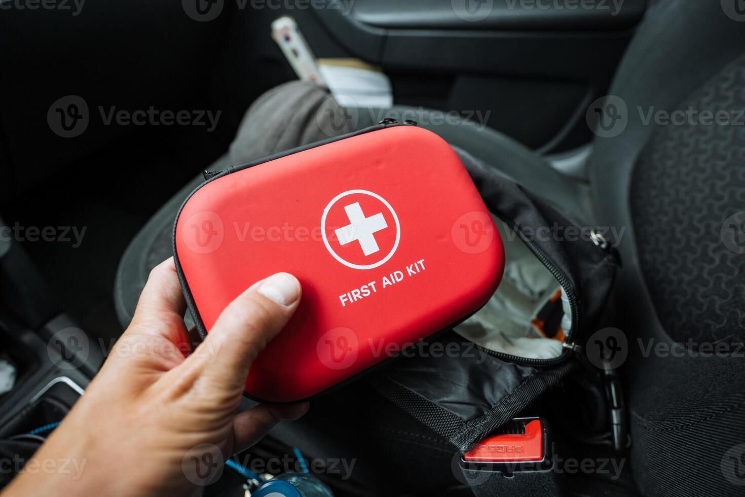 A person is calmly and confidently holding a bright red first aid kit tightly in their hand, fully ensuring that they are wellprepared for any potential emergency situations that may arise photo