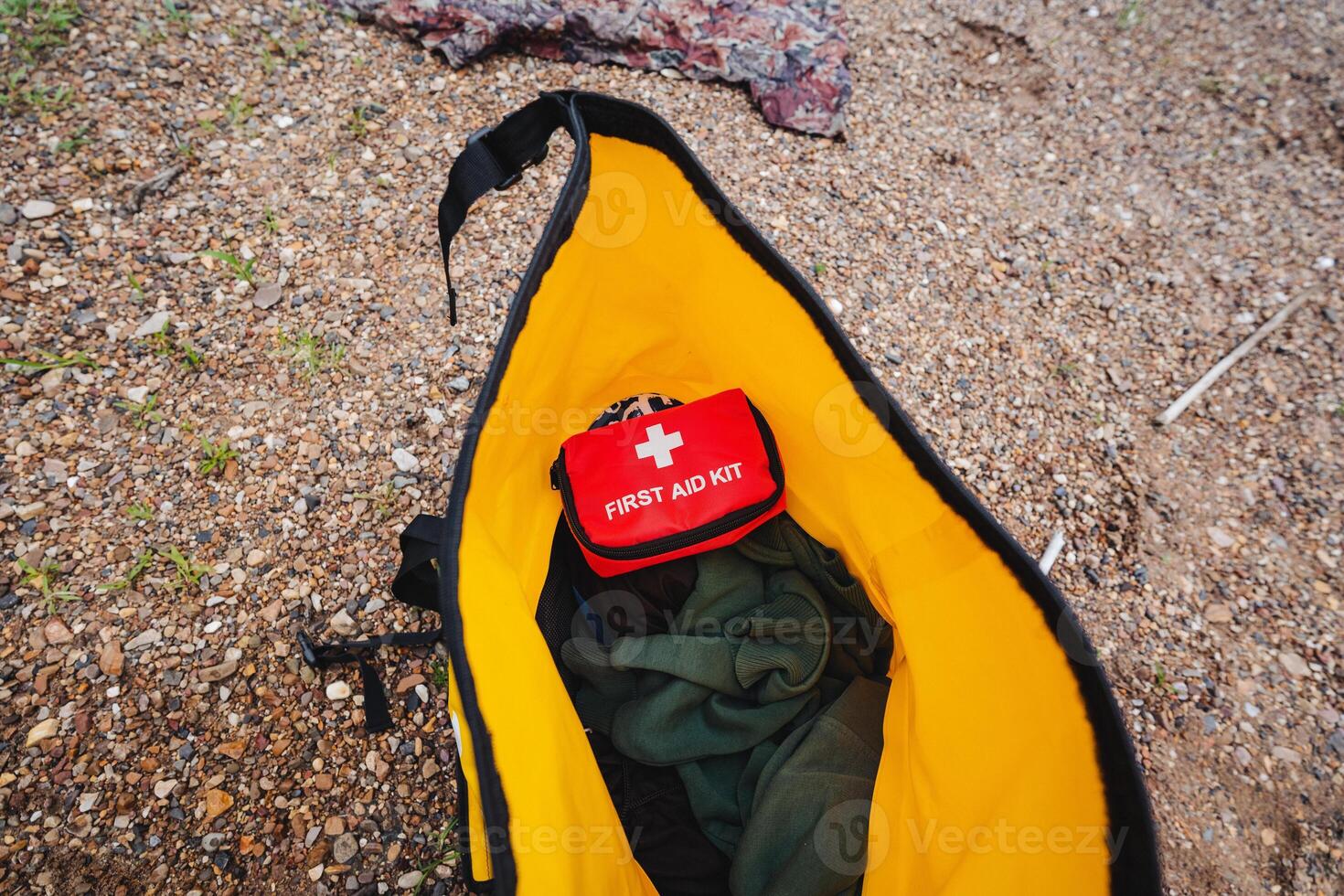 Inside a bright yellow bag, youll find a red first aid kit that is crucial for handling unexpected emergencies or engaging in any outdoor activities that may arise in the wild photo