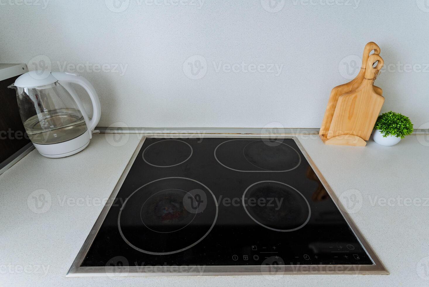 On a kitchen counter, there is a stove top oven placed right beside a cutting board, creating a functional cooking space filled with essential kitchen tools that aid in meal preparation photo
