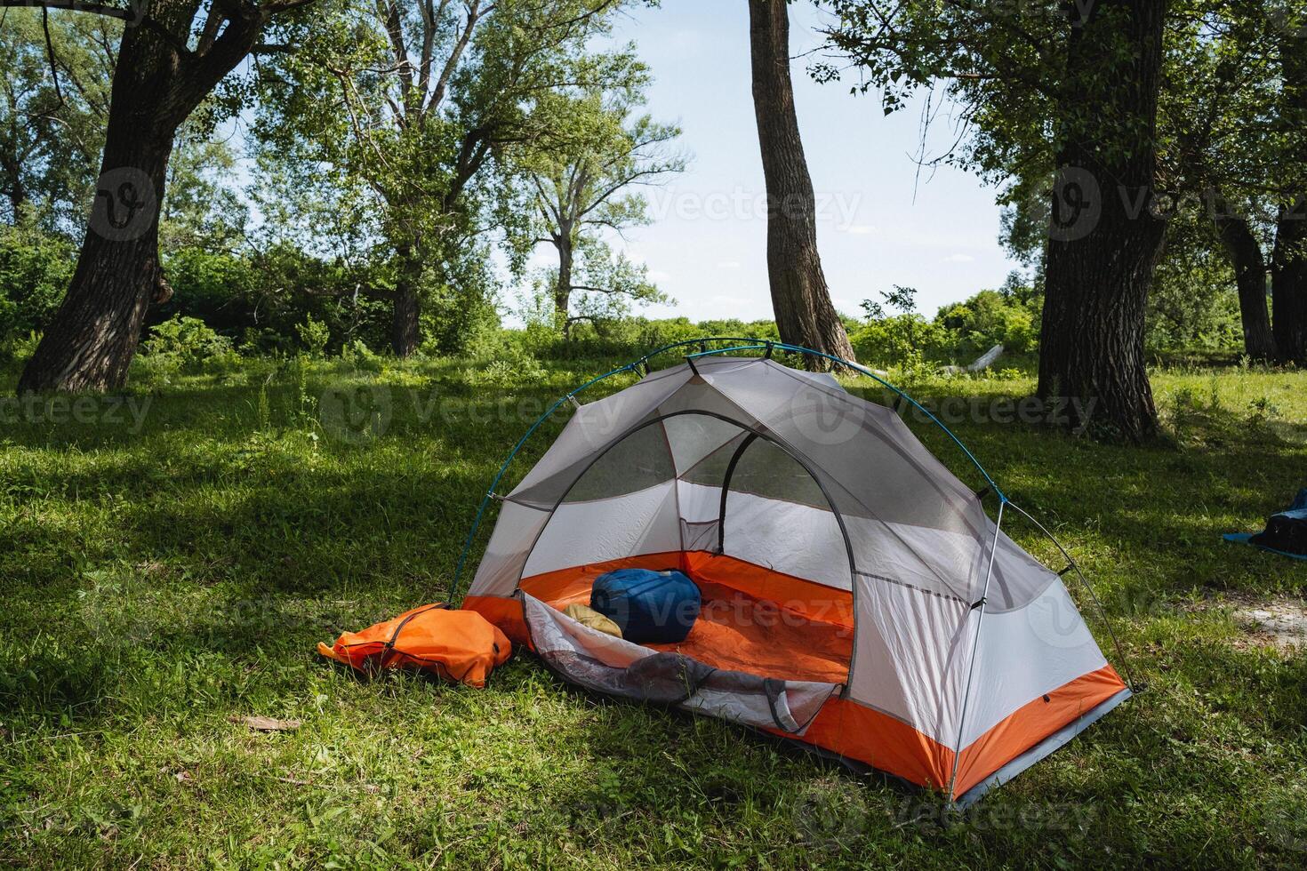 Imagine a cozy camping tent nestled peacefully, surrounded by lush greenery and vibrant nature that invites leisure and exploration. Perfect for those seeking an escape into the stunning outdoors photo