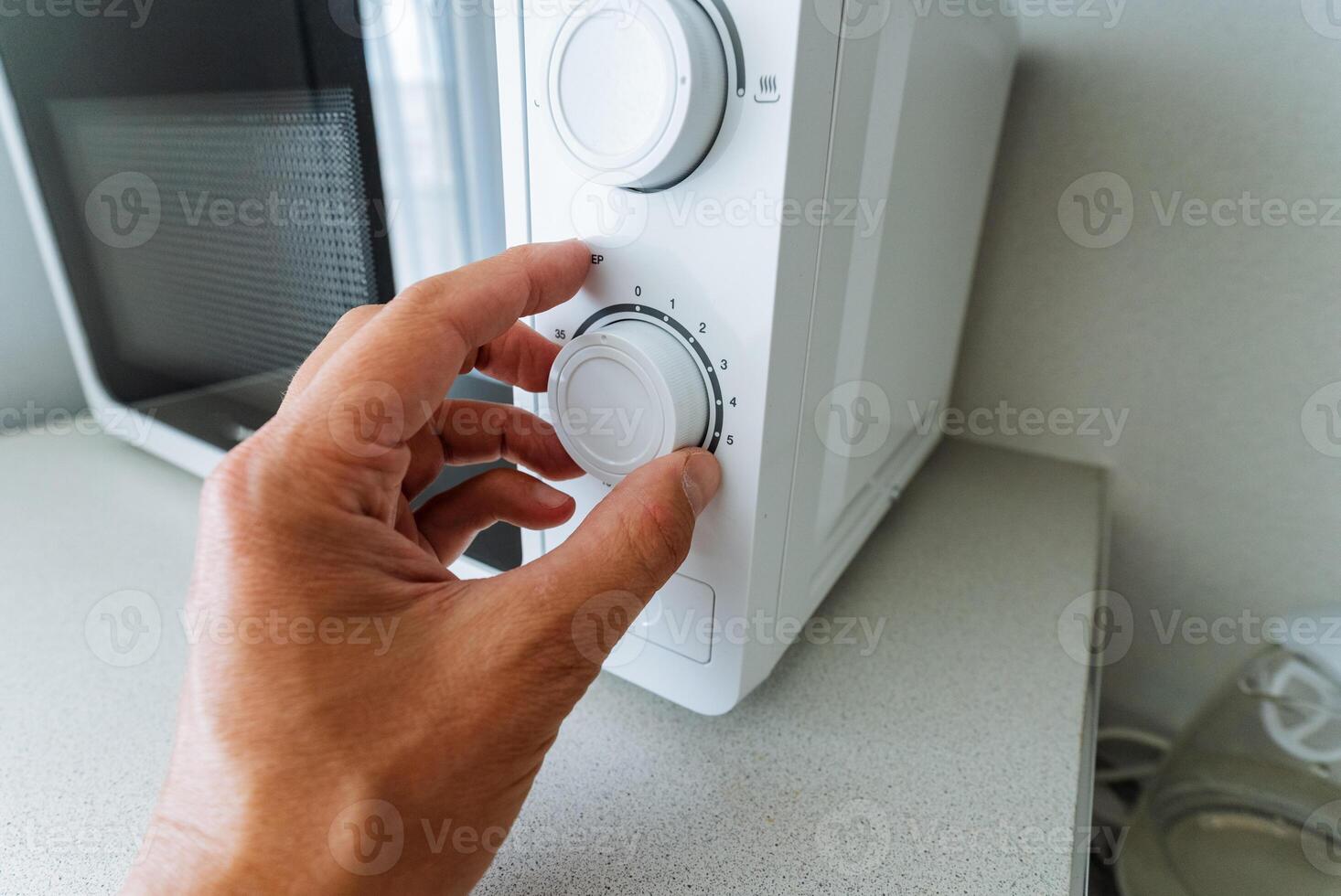 A person is in the process of adjusting the temperature settings of a microwave oven, ensuring that it functions perfectly for the food they plan to heat or cook inside it photo