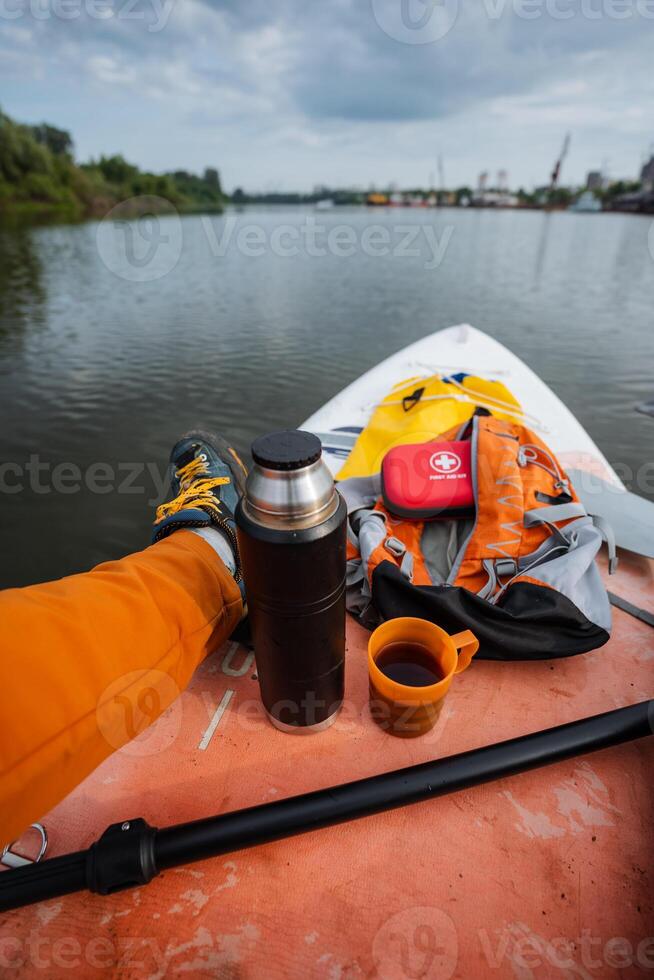 Paddleboarder relaxing with a thermos photo