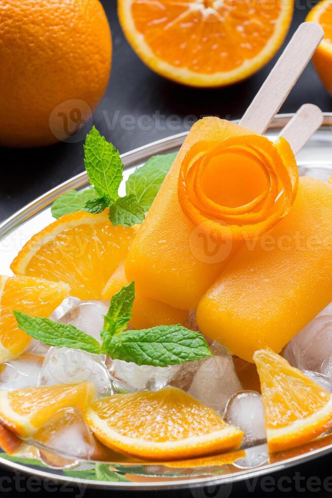 Orange popsicles with mint and ice photo