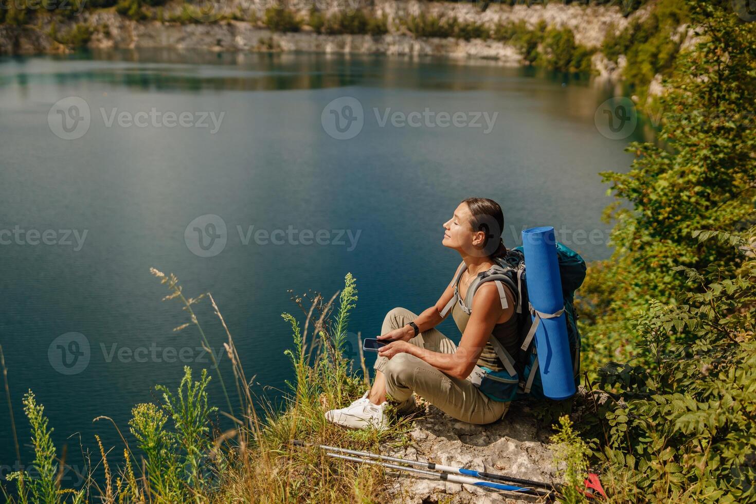 A Serene Hiker Enjoying a Beautiful Day by a Tranquil Lake Surrounded by Natures Beauty photo