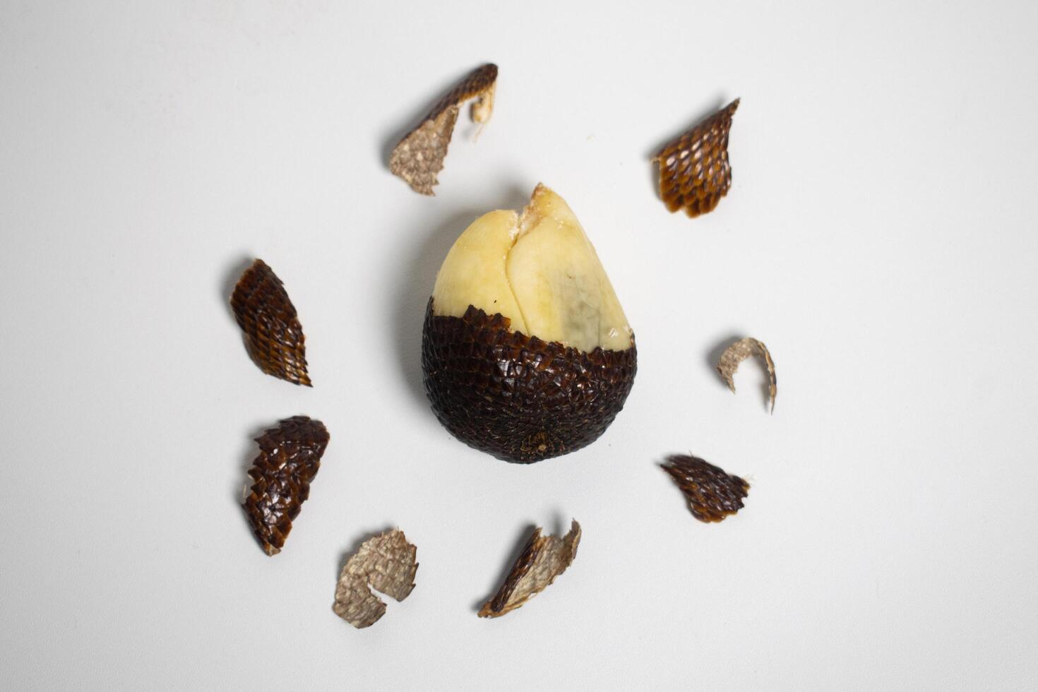 Peeled snake fruit Salak with scattered scales. photo