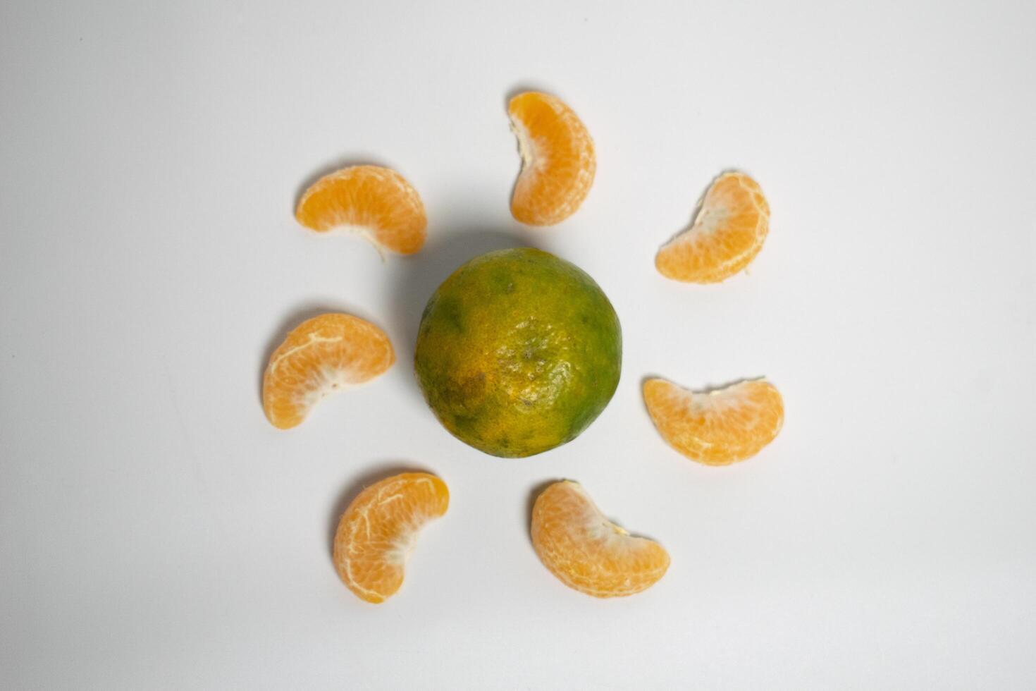 Citrus creativity orange segments form a circle around a whole fruit, resembling a sunburst. photo