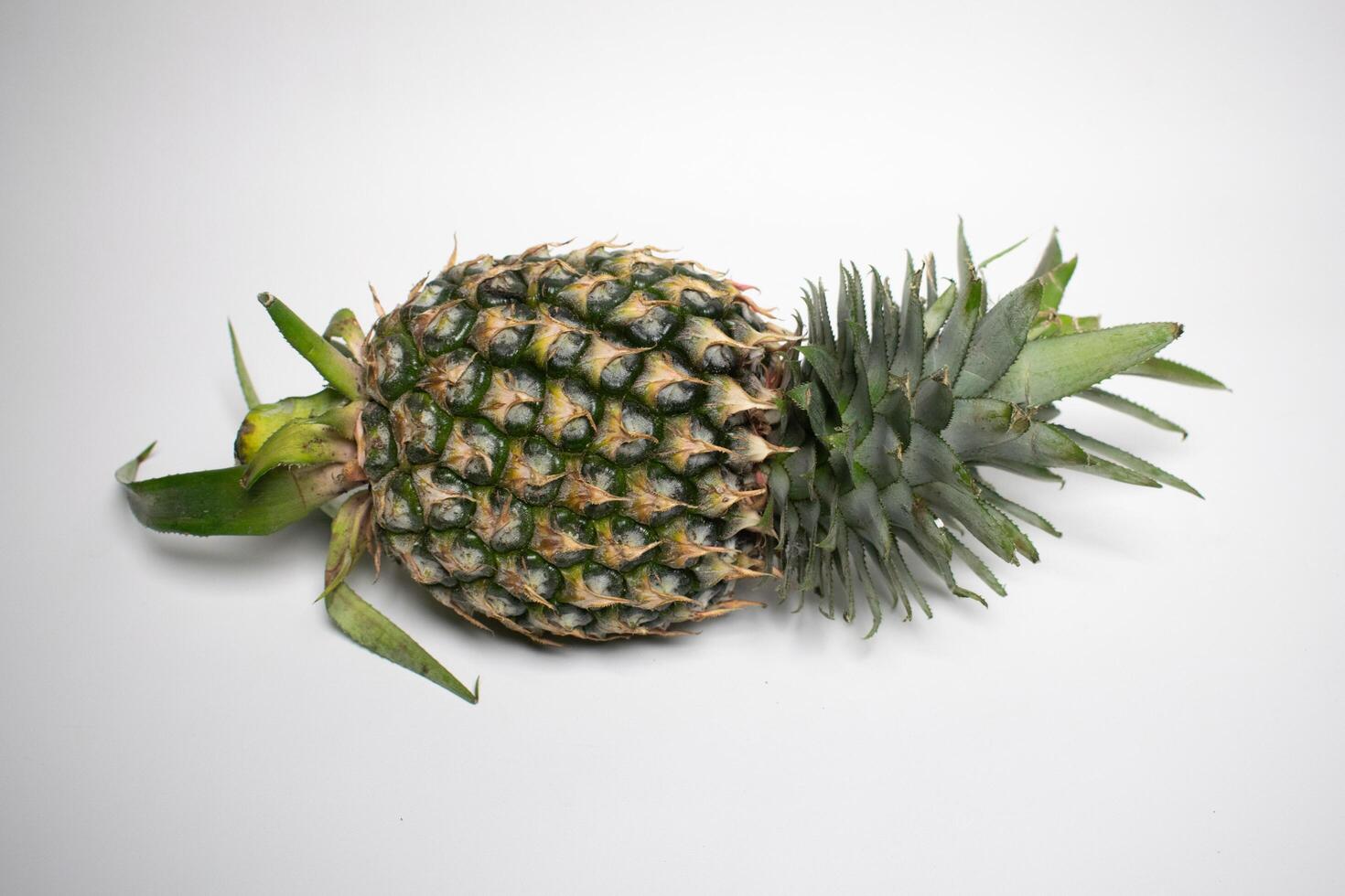 Fresh whole pineapple lies on a white background. photo