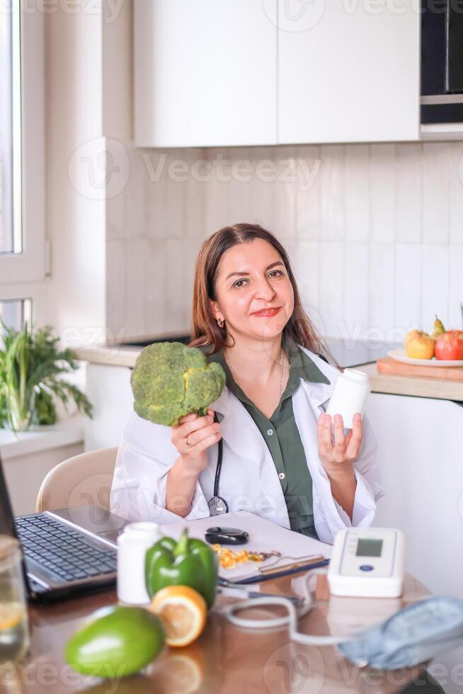 nutritionist doctor shows broccoli and dietary supplements as part of a healthy diet for women. fitness and diet concept. photo