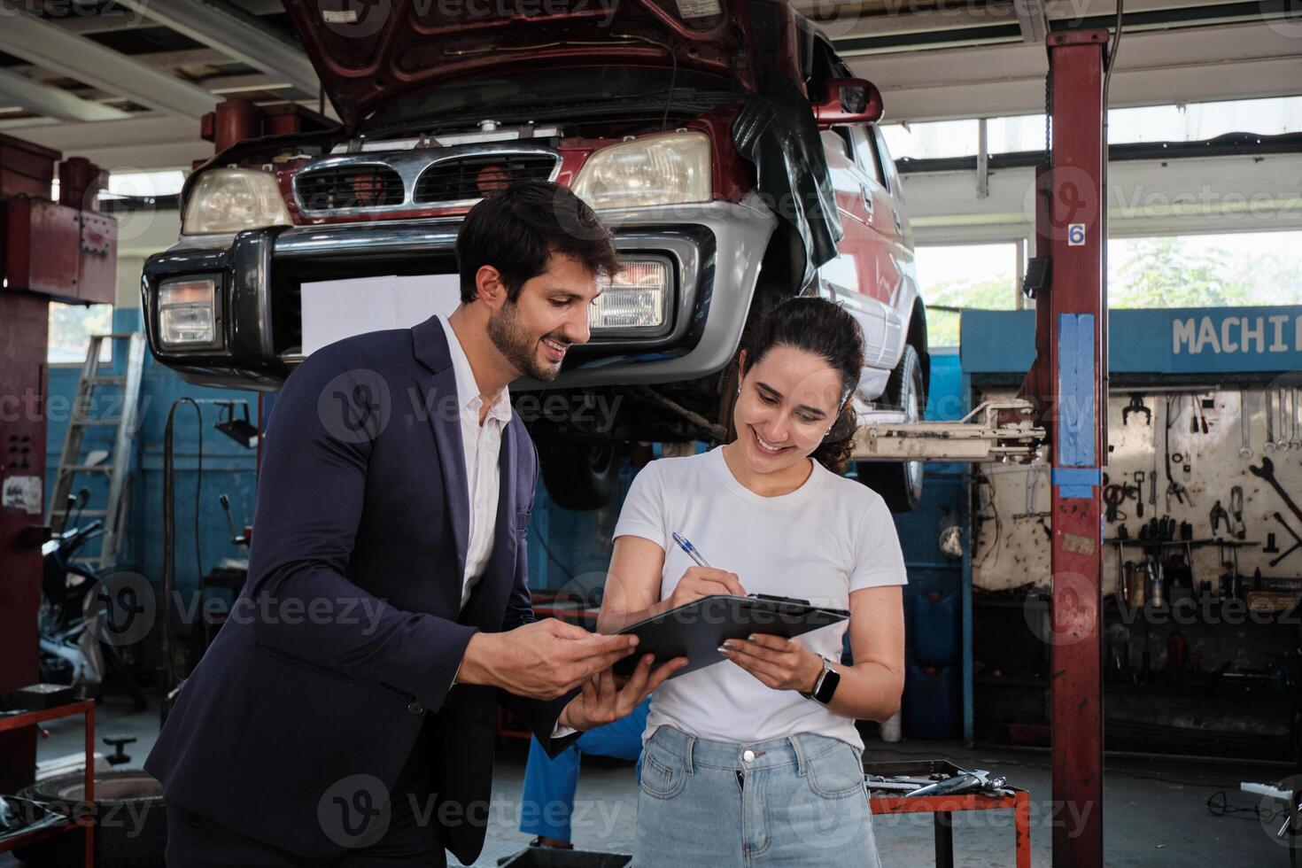 Warranty service business work, Latino female client cheerful inspections sign contract document from Hispanic male insure agent with smiles, accept claims car fix and maintain at automotive garage. photo