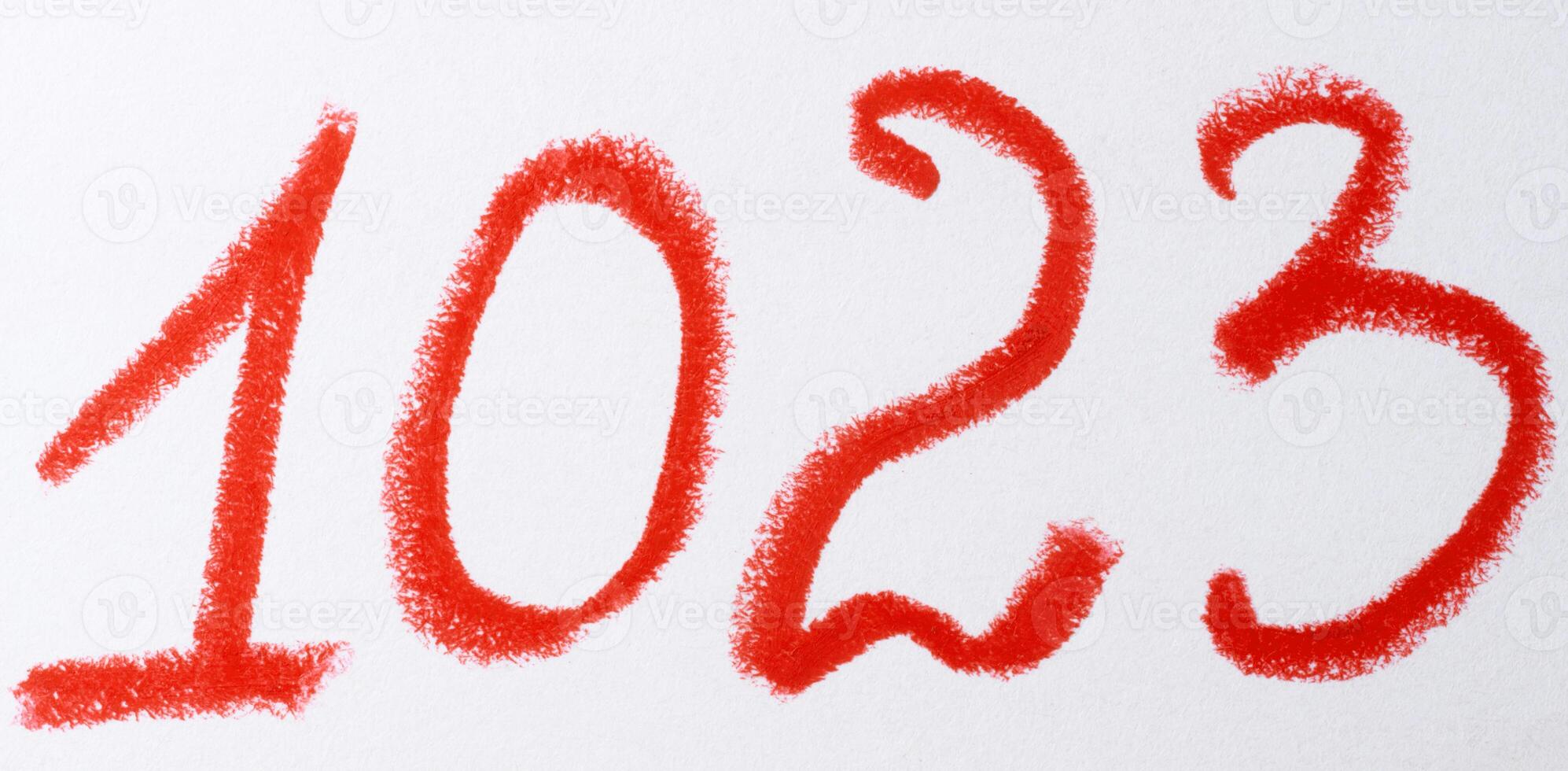 A number written in red chalk or pastel on a white background, with the texture of the strokes visible photo