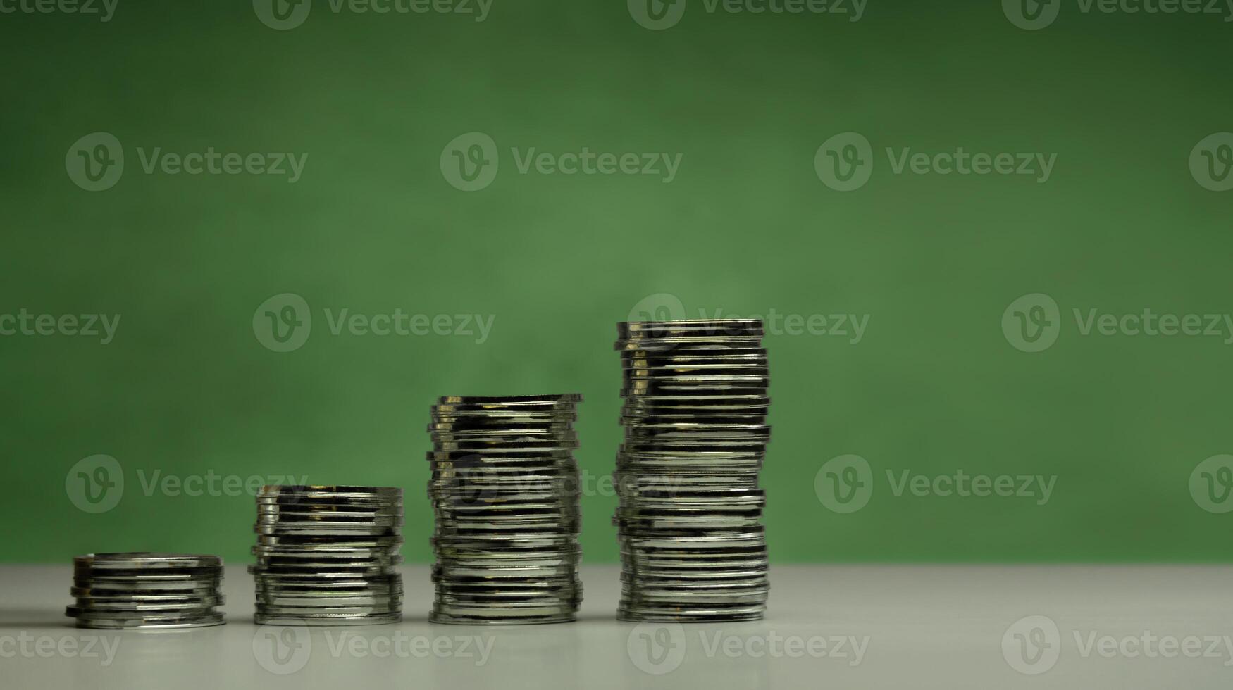 Stacked coins ascending order on green background from Low to High, representing economic recovery, financial growth, increasing savings, profitable investments photo