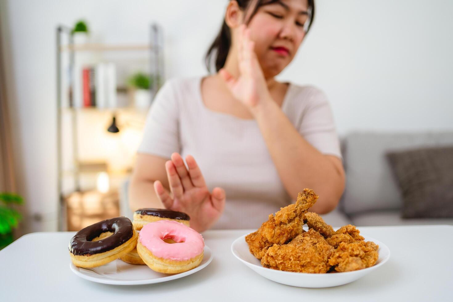 A woman refuses to eat fast food, fried chicken and donuts on her plate to lose weight and healthy photo