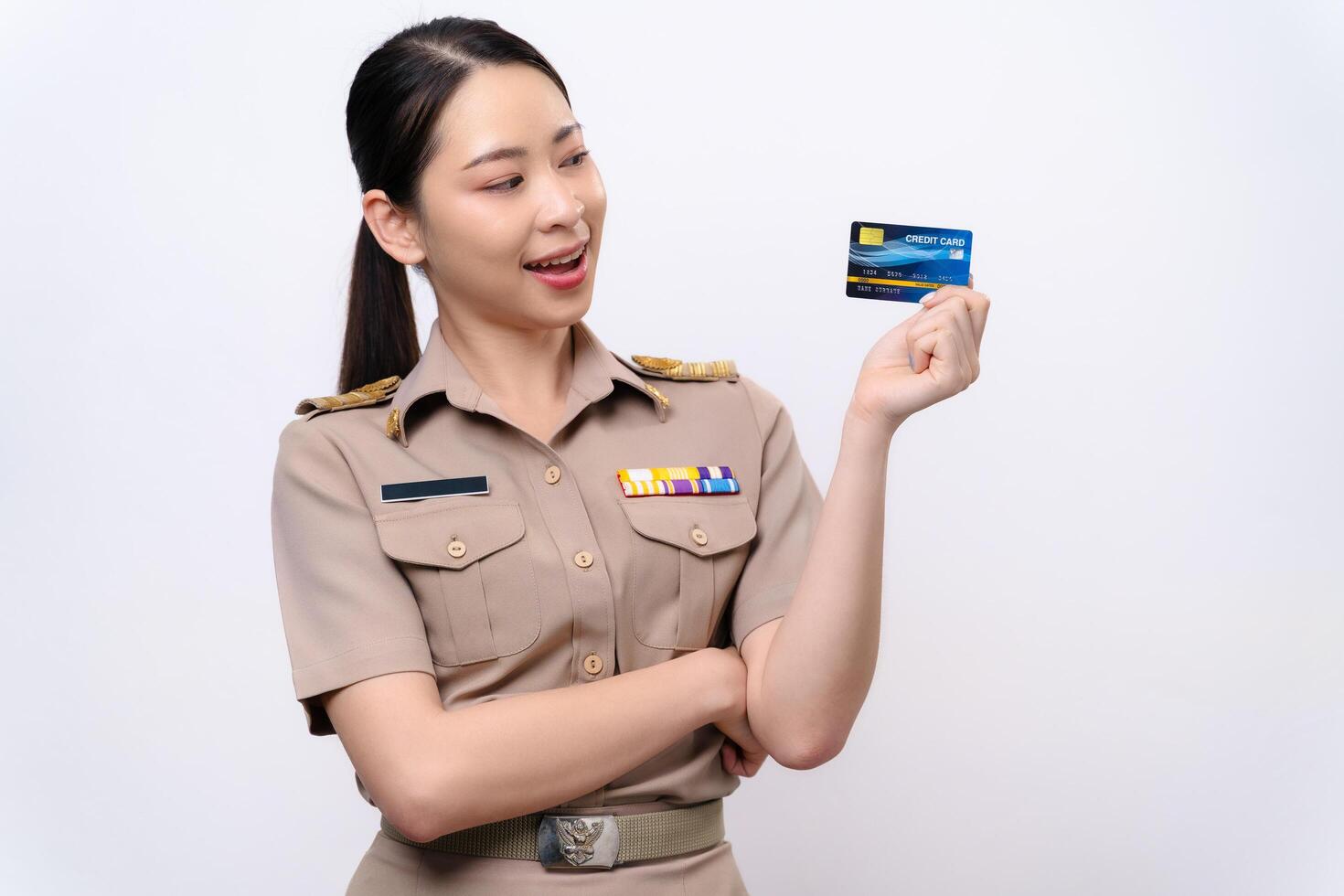 Young Thai Asian Teacher in uniform is holding the credit card and look at the camera photo