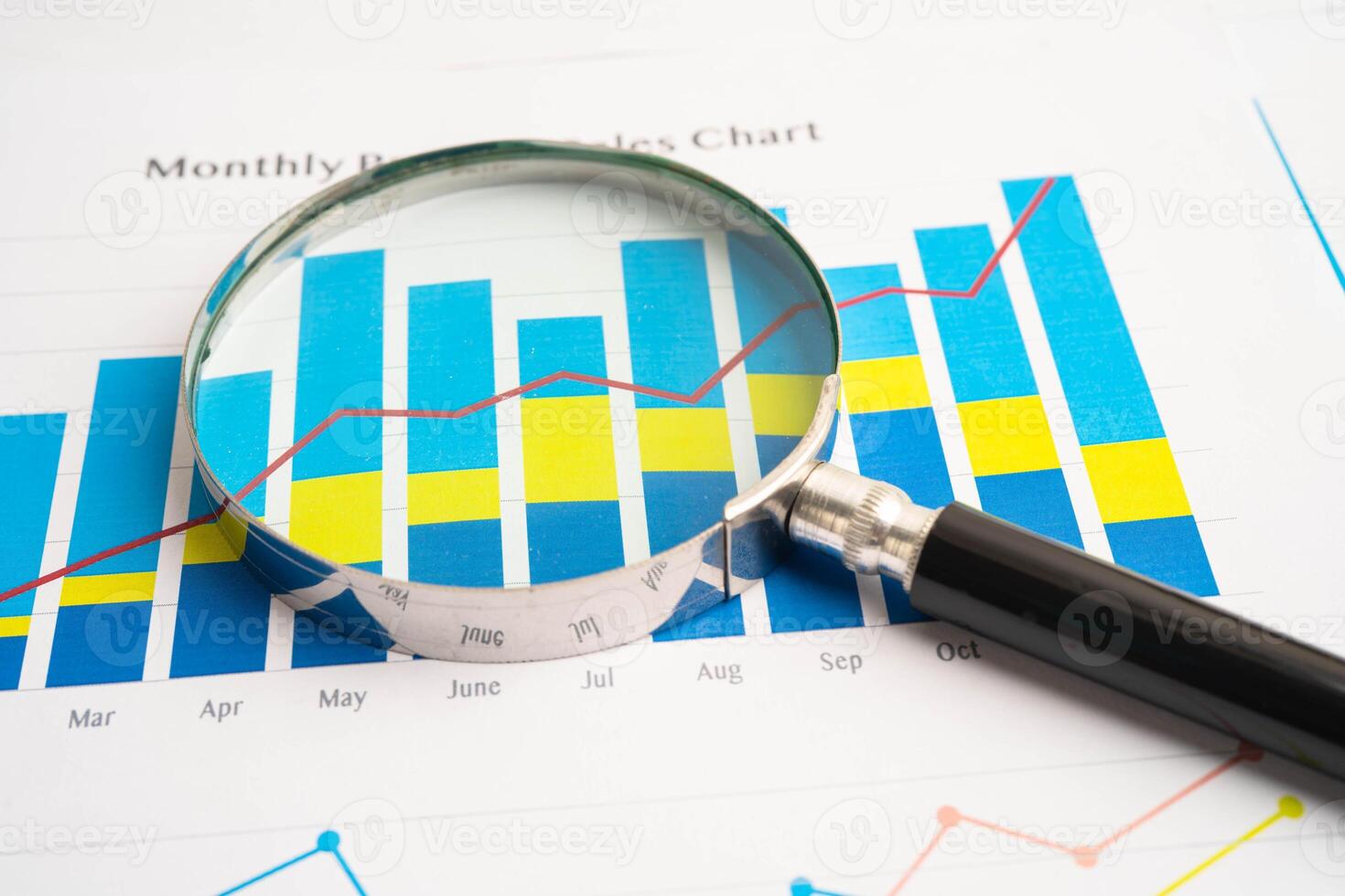 Magnifying glass on data business graphs photo