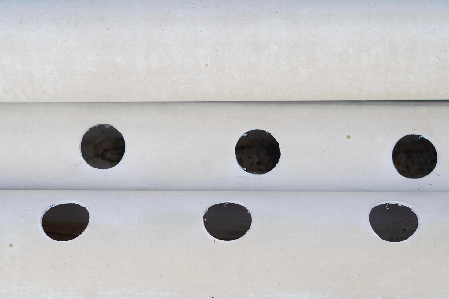 White pipe with round holes along the pipe photo