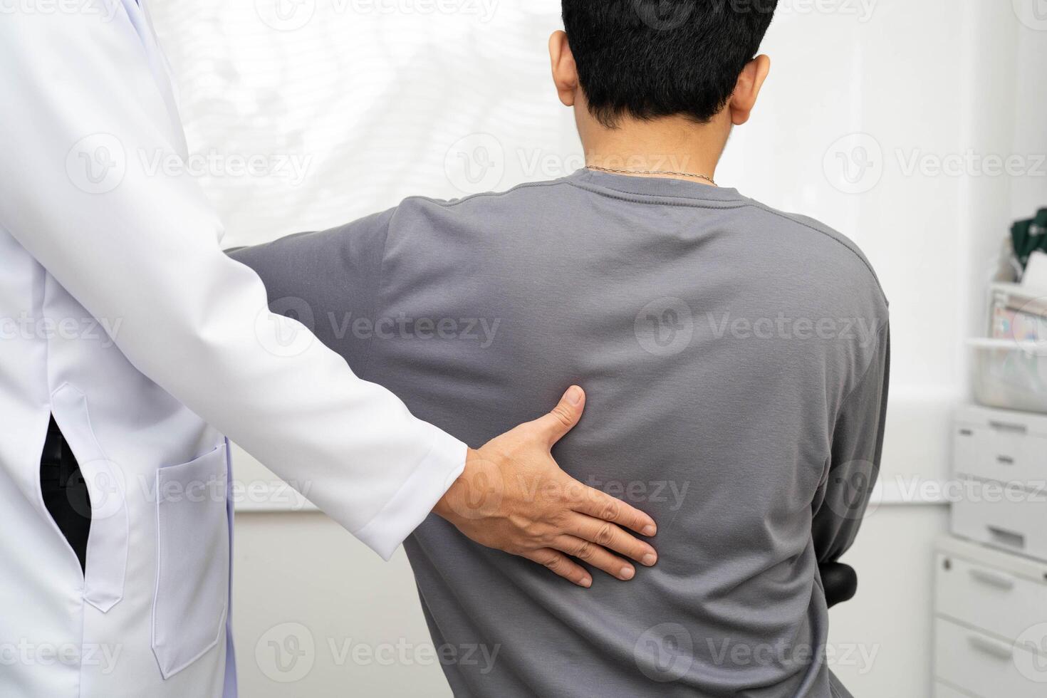 Physical therapist doctor treat perform pain young man in hospital. photo