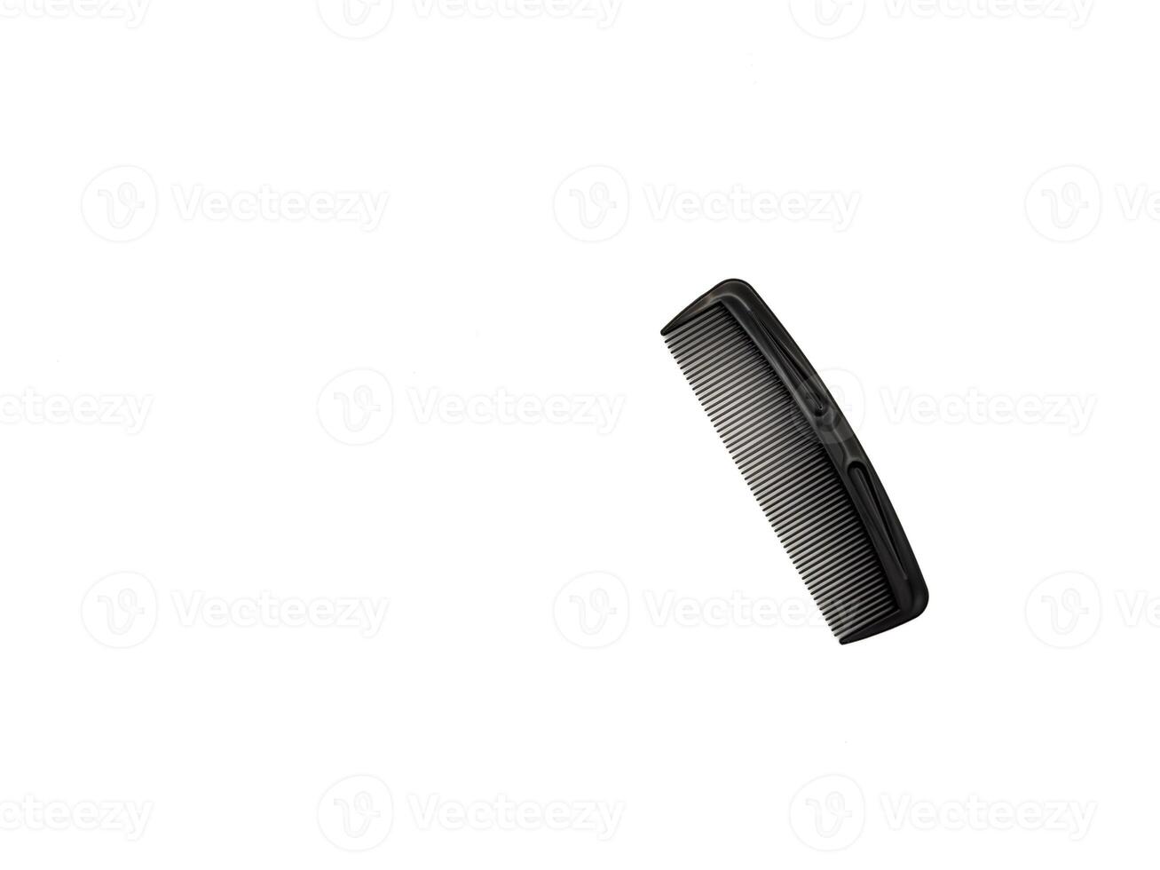 A black comb with a black handle. The comb is laying on a white background, copy space, flay lay, top view photo