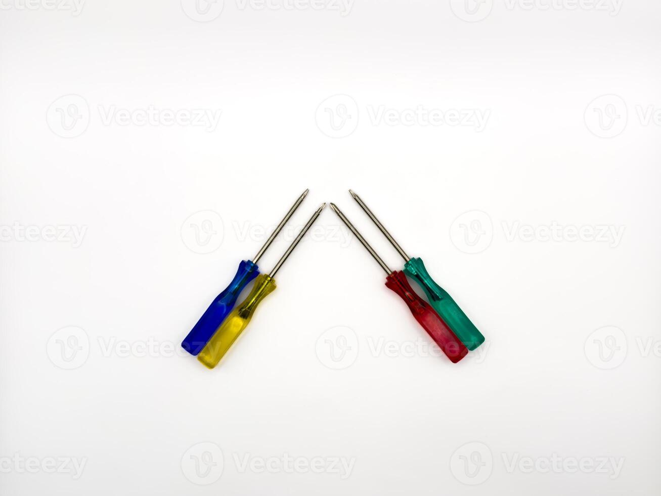 Four small colored plastic screwdrivers on a white background. copy space, flay lay photo