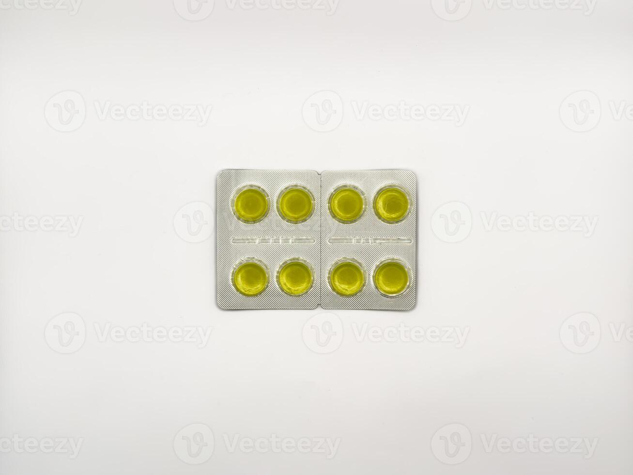 A yellow pill is on a white background. There are six pills in total. The pill is in the middle of the image, copy space, top view photo
