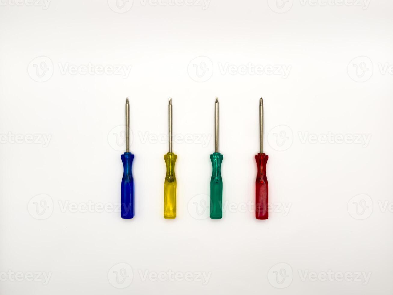 Four small colored plastic screwdrivers on a white background. copy space photo