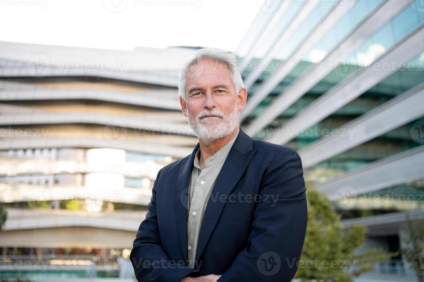 Senior businessman standing in front of modern office building photo