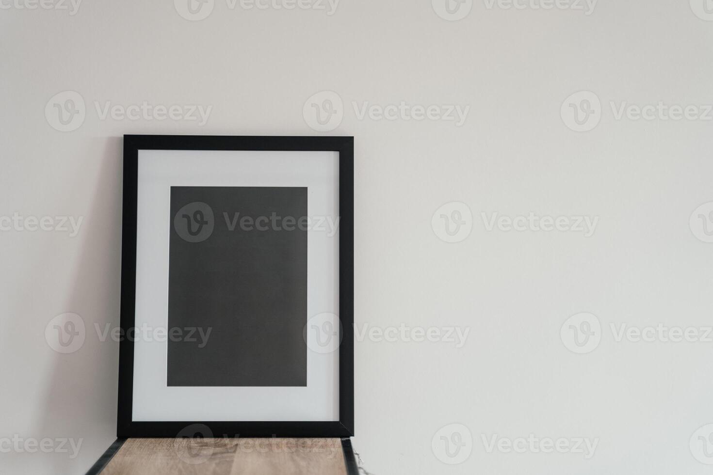 Blank wooden photo frame stands in the interior on a white background. Mockup poster frame.