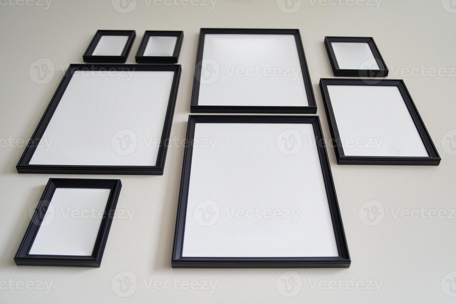 Different size framed photos hanging on the gray wall. Mockup.