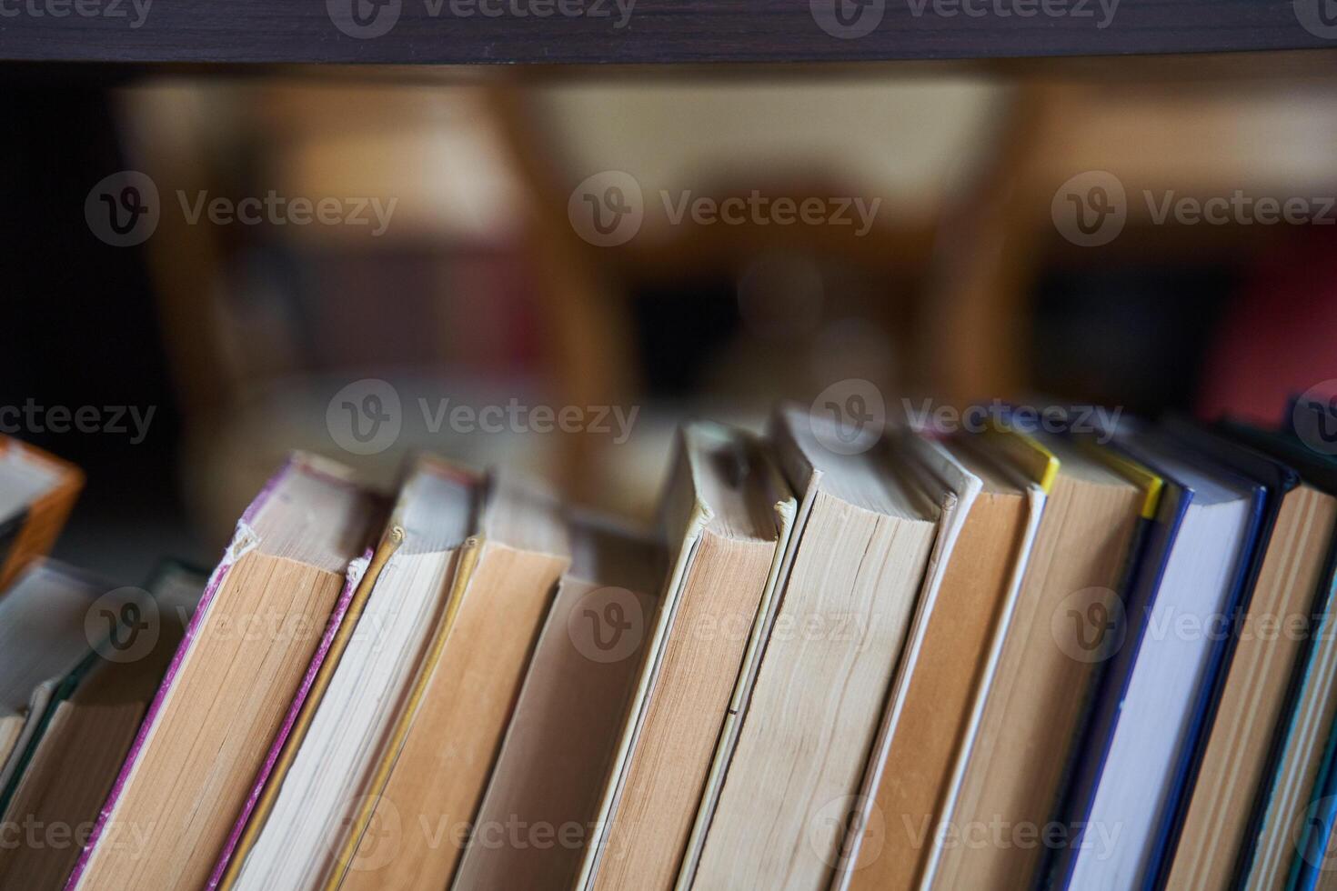 piles of books on a wooden bookshelf. photo