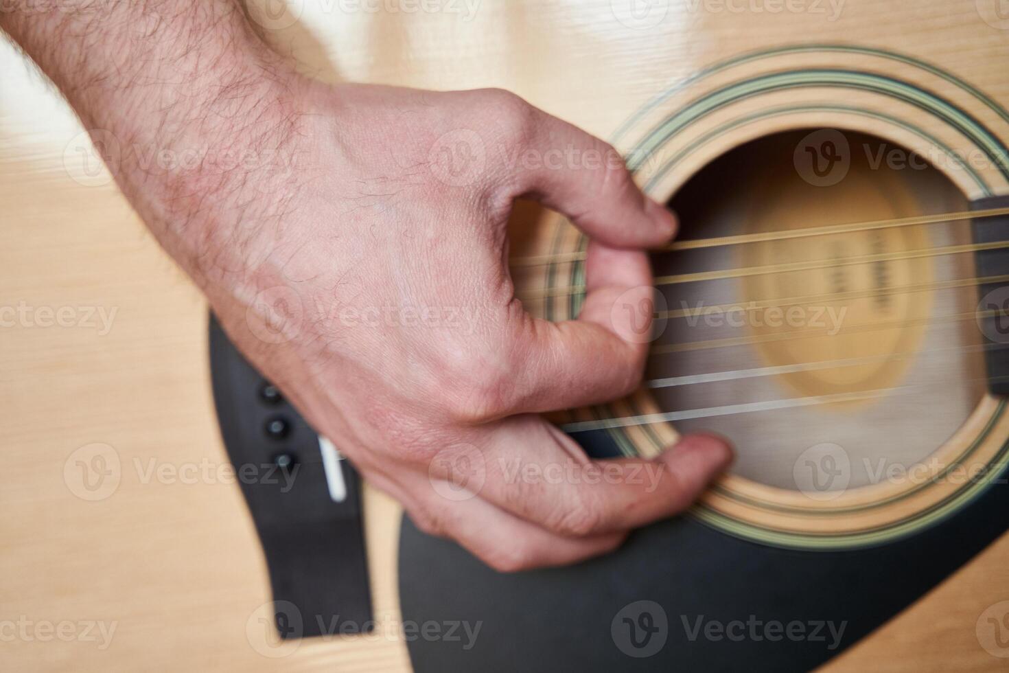 Musician Hand on Acoustic Guitar. Close up photo