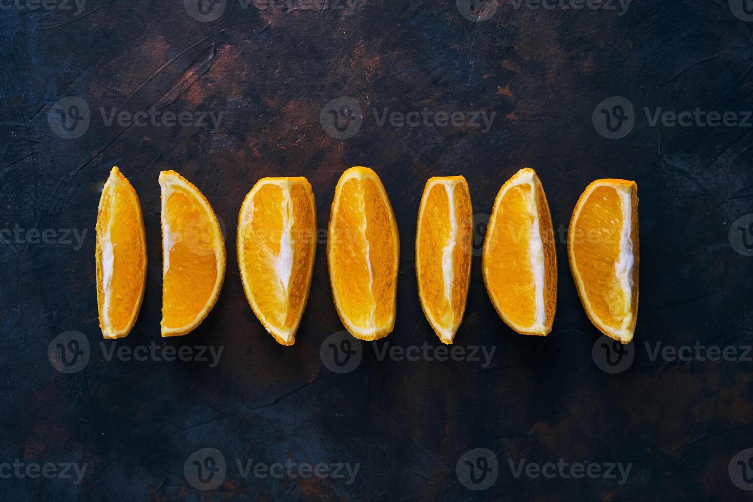 Seven Orange slices on a dark background. photo