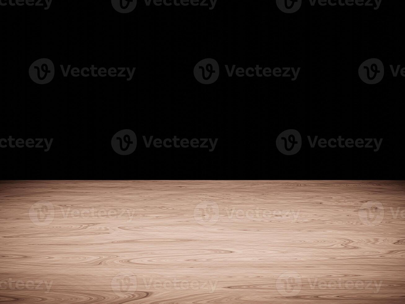 Natural wood table top illuminated by soft light, contrasting with a black background. photo