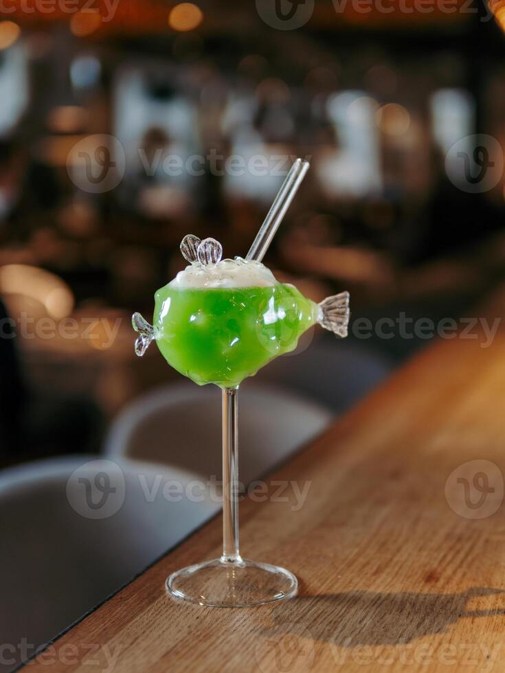 Green fish cocktail with straw photo
