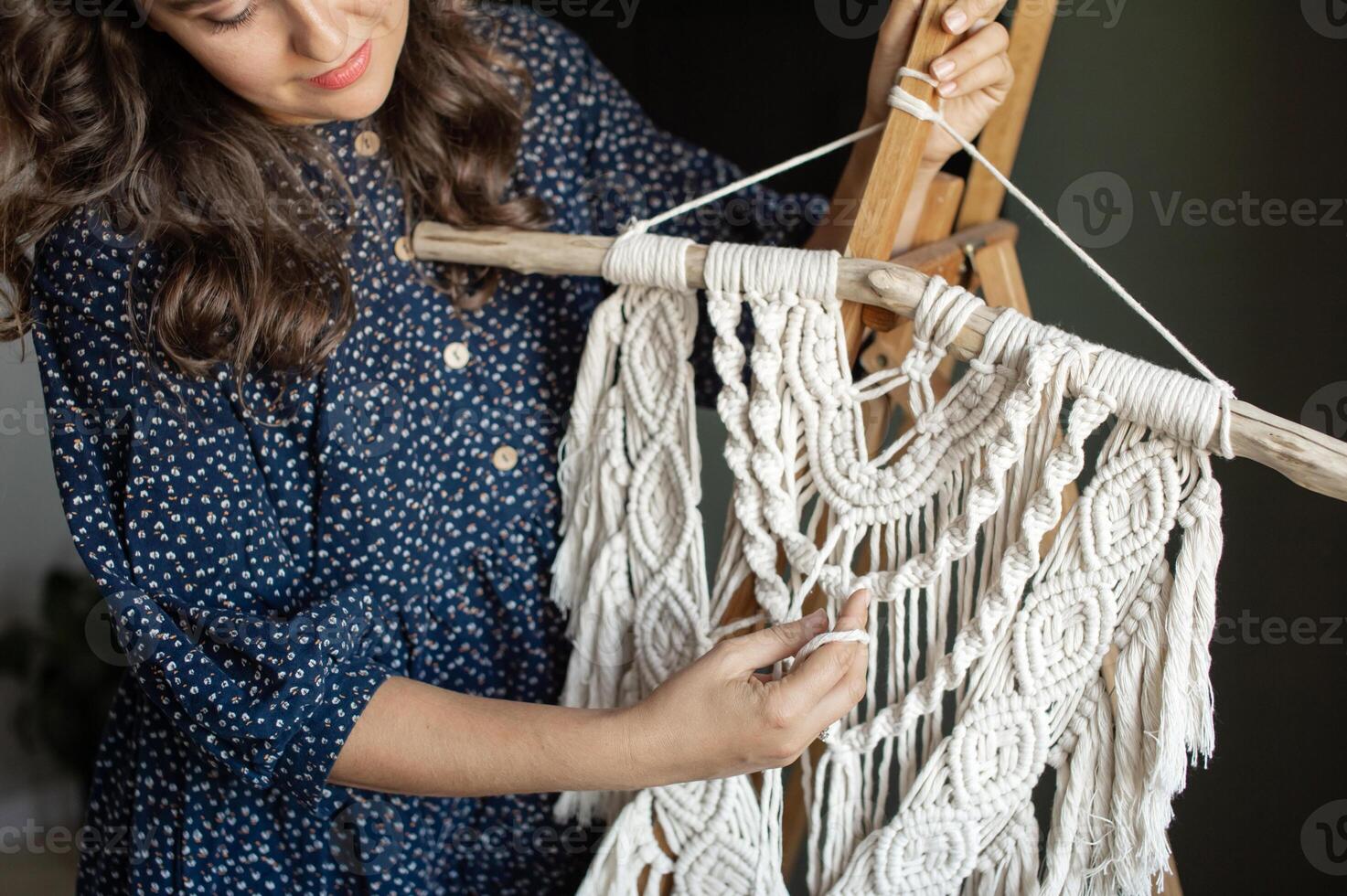 Smiling Woman Crafting Macrame Wall Hanging at Home. photo
