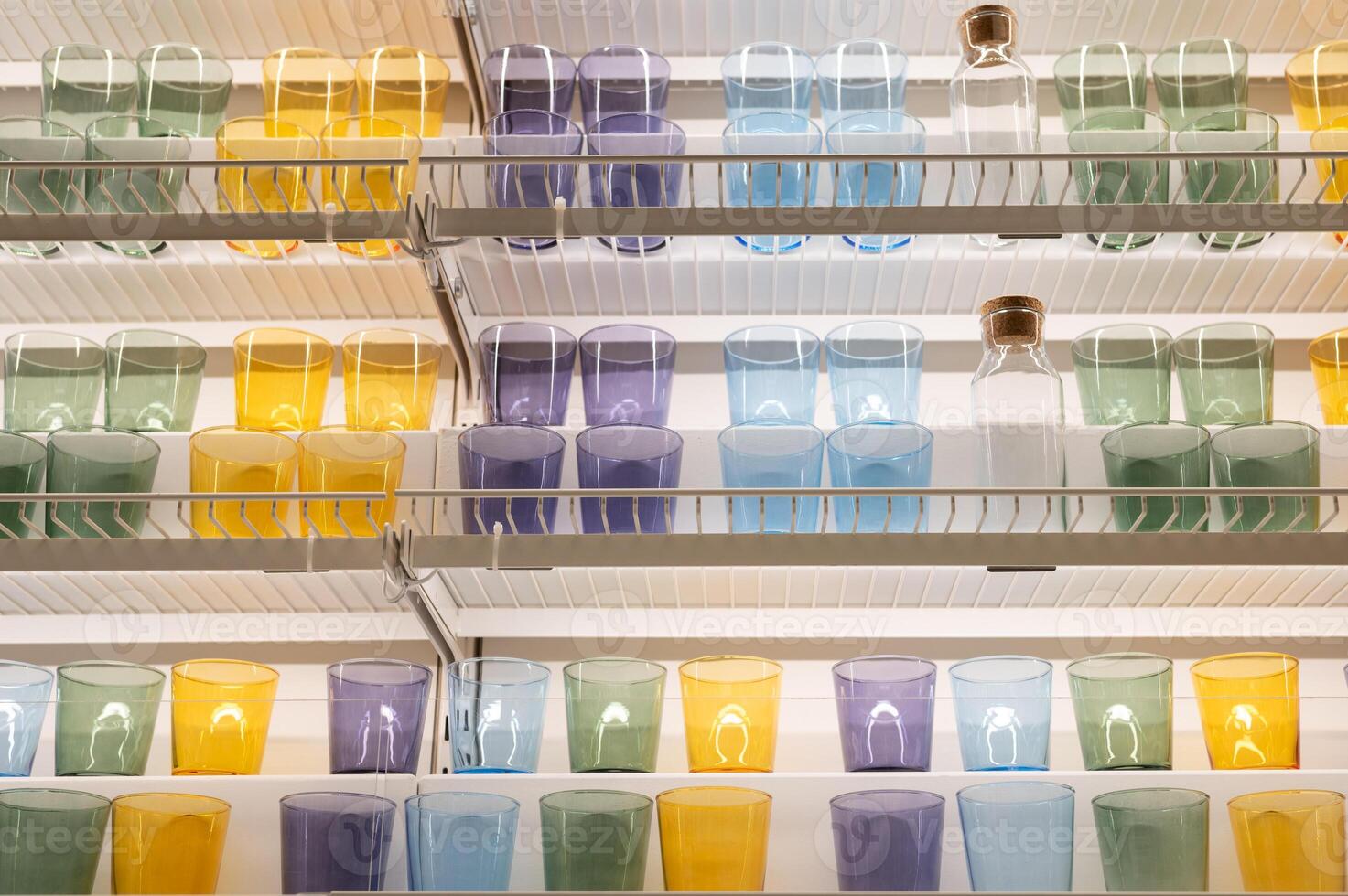 Colorful glasses and bottles arranged on shelves in a pantry setting photo