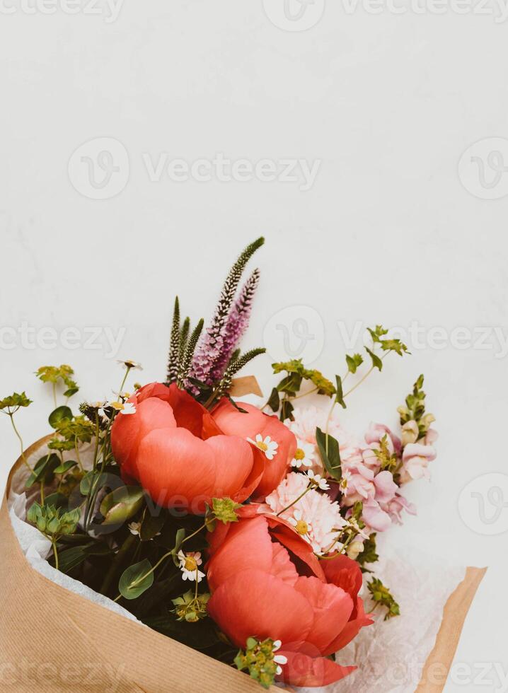 Beautiful bouquet with red peony and other flowers on white table photo