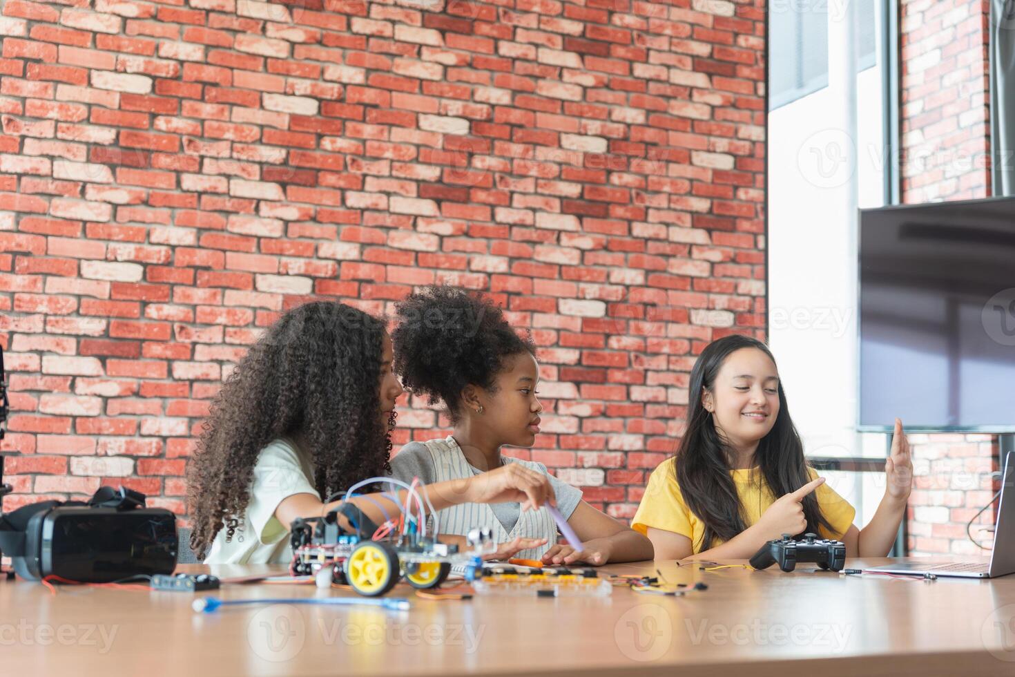 Children Learning Robotics, Young Girls Engaged in Robotics and STEM Learning, Diverse Kids Building a Robot Arm in a Science Workshop, Girls Exploring Technology and Innovation photo