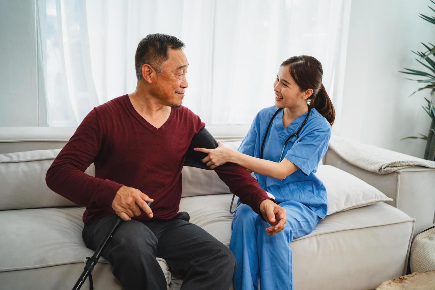 Nurse checks senior man's blood pressure photo