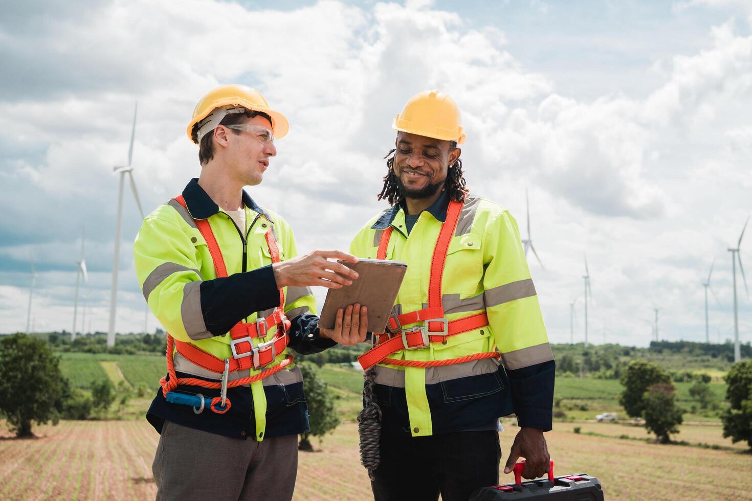 Two men in safety gear are looking at tablet photo