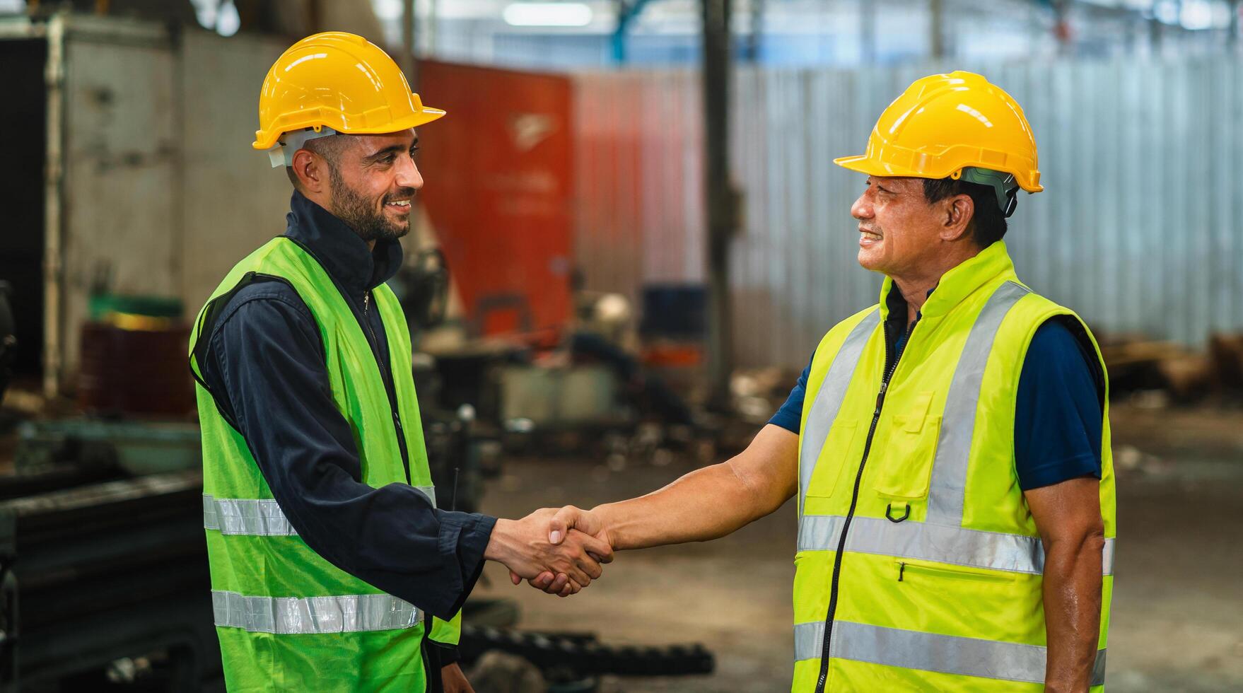 Construction workers shaking hands indoors photo