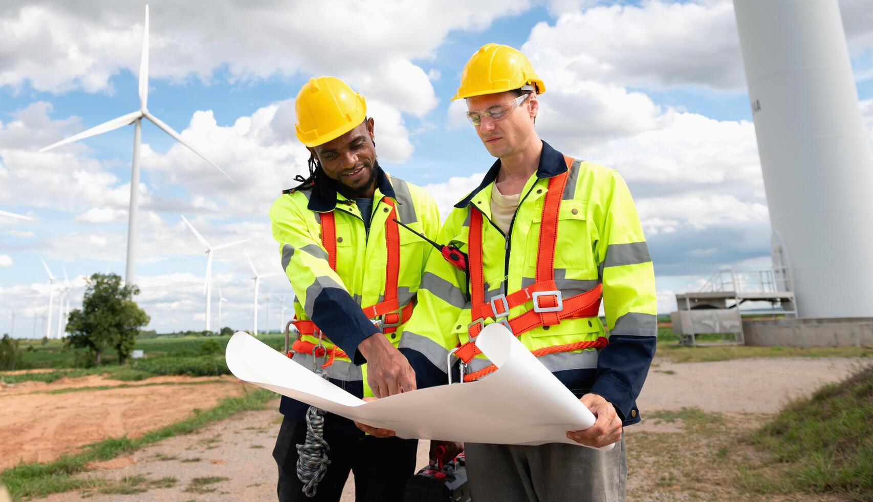 Engineers examining wind energy plans outdoors photo