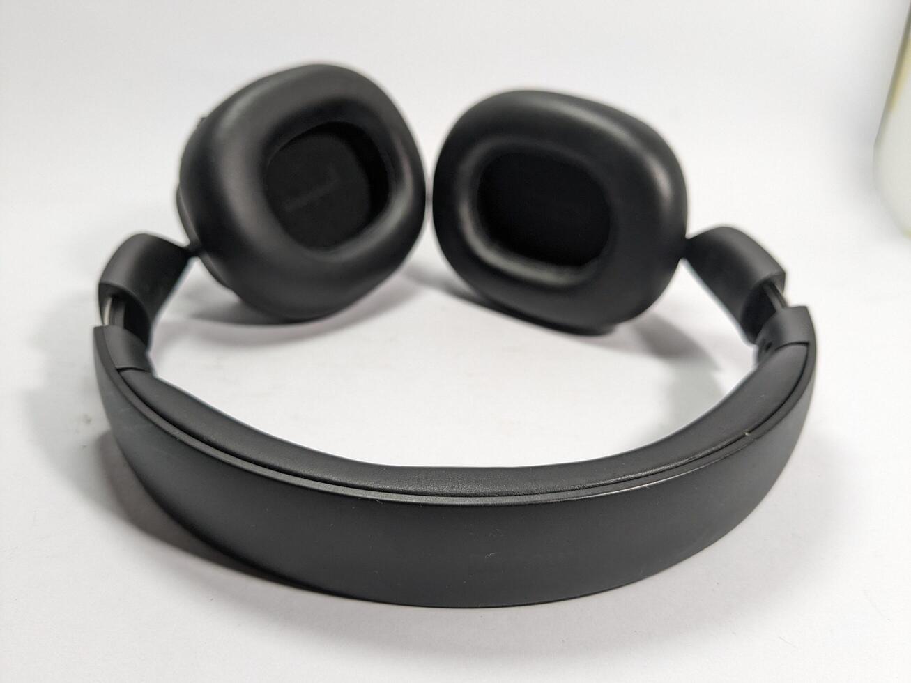 Close up of black wireless headphones on a white surface, ready for music listening. photo