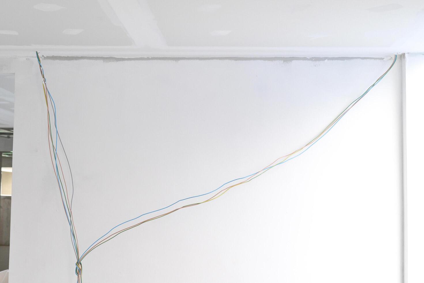 Interior renovation building phase showcasing gypsum board ceiling with smooth edges. Electrical wire installation continues before plastering of ceilings. Successful project relies careful photo