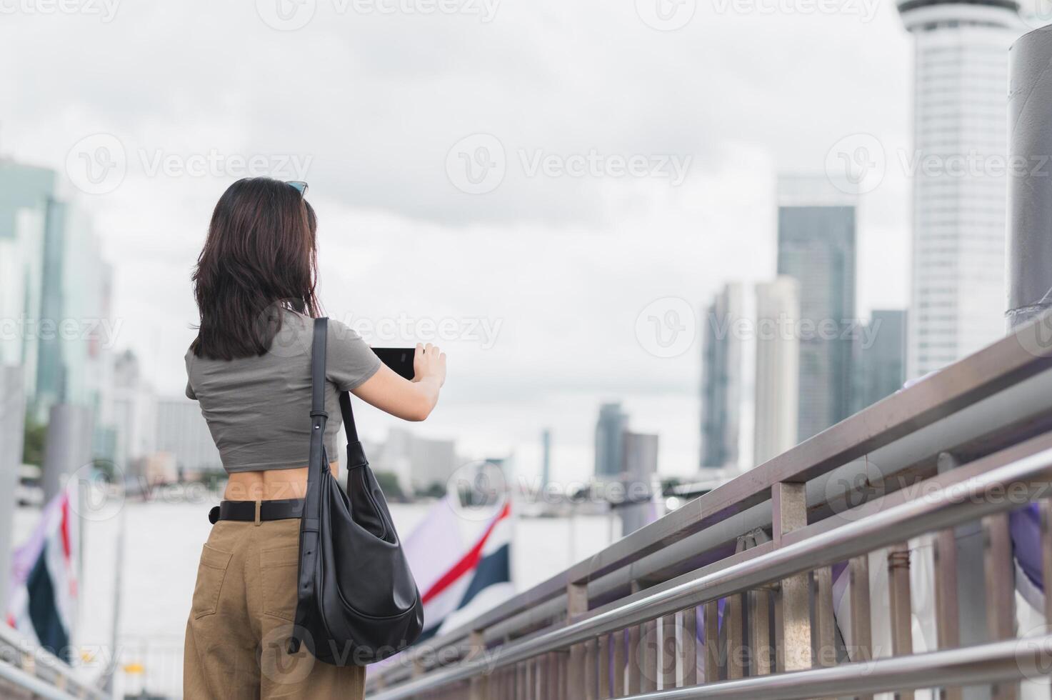 Solo southeast asian woman teenager blogger world travel explorer wait to take photo with smartphone. Local cultural experience and asia tourism concept express boat Chao Phraya River Bangkok