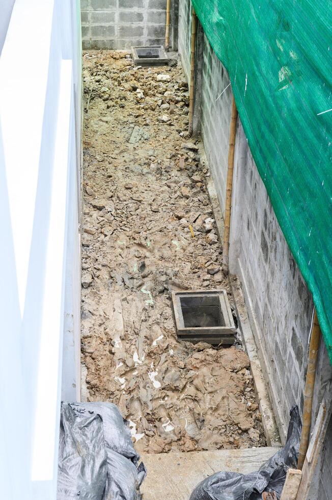 High angle view of messy passage during major house renovation. dug up ground and rubble show demanding process of home improvement and exterior construction work photo