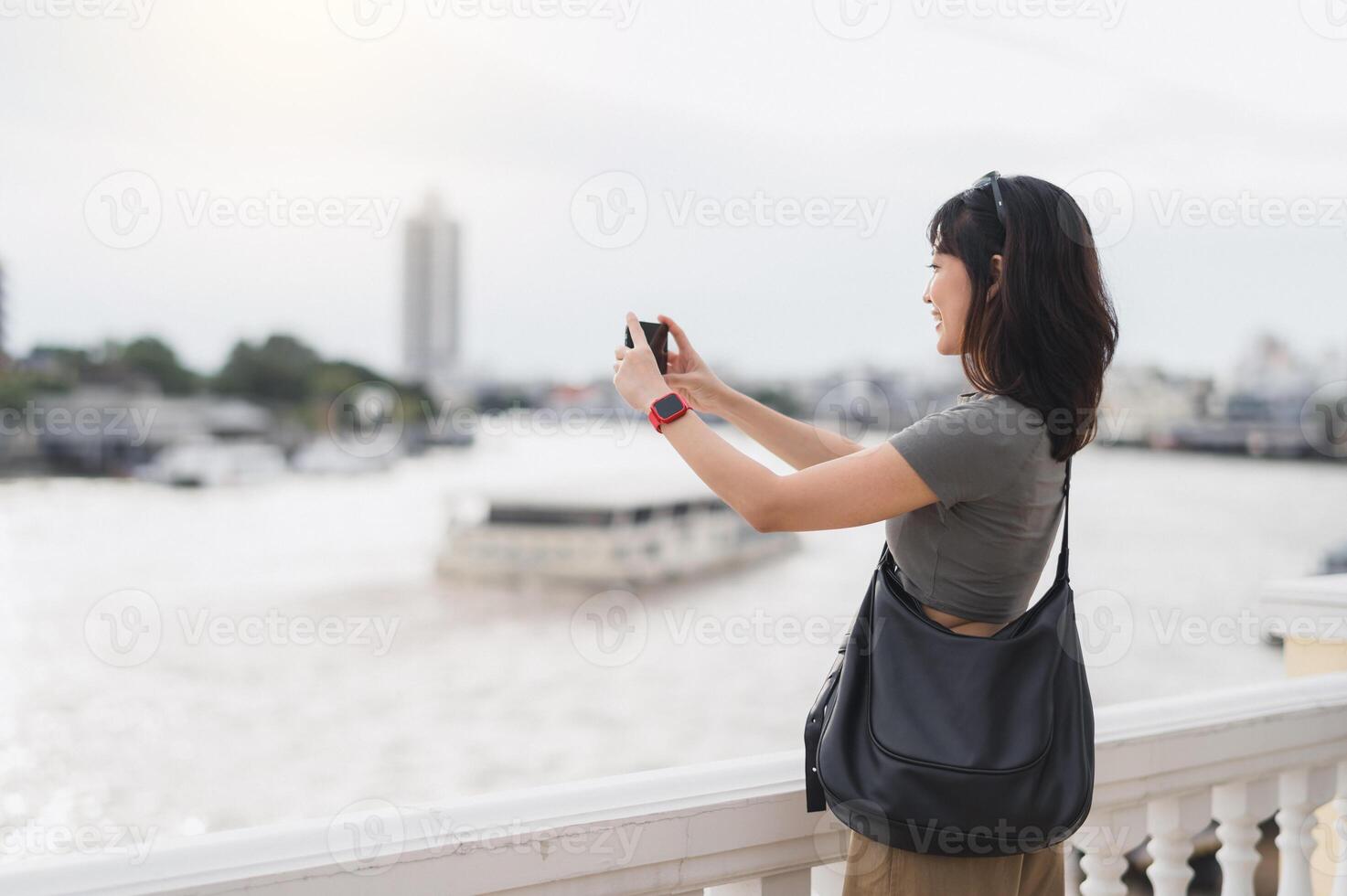 Solo southeast asian woman teenager blogger world travel explorer wait take photo with smartphone express local cultural experience on boat Chao Phraya River Bangkok Thailand asia tourism concept