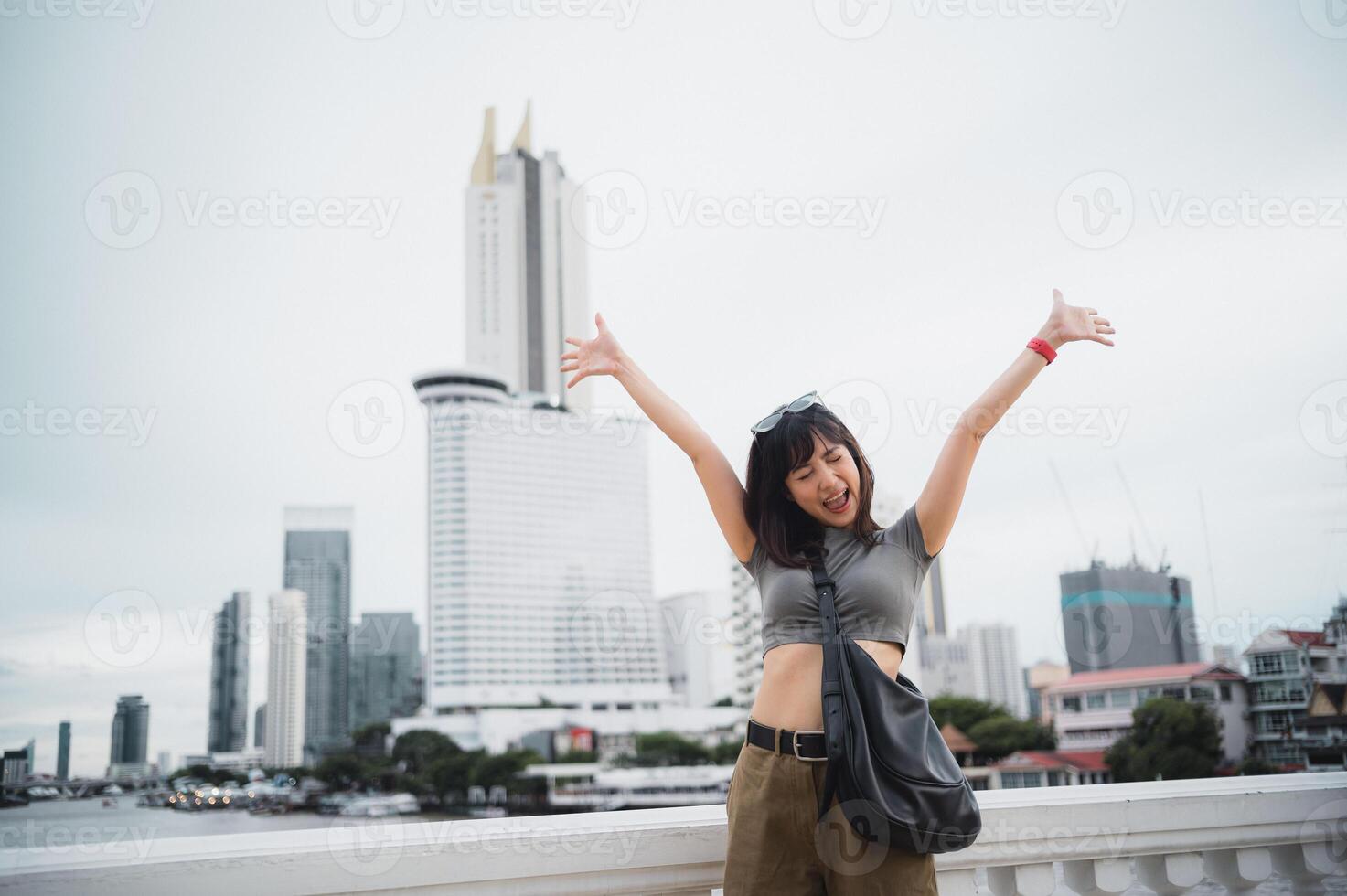 Happy young southeast asian woman teenager blogger on solo tourism using smartphone. Local cultural world travel explorer experience concept in Asia. Bangkok Thailand by Chao Phraya river photo