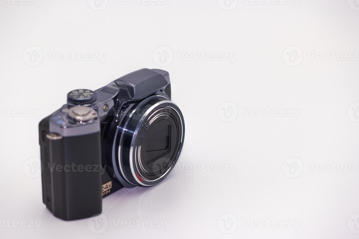 Compact digital camera positioned on a white surface showcasing modern design with clear lens and creative potential photo